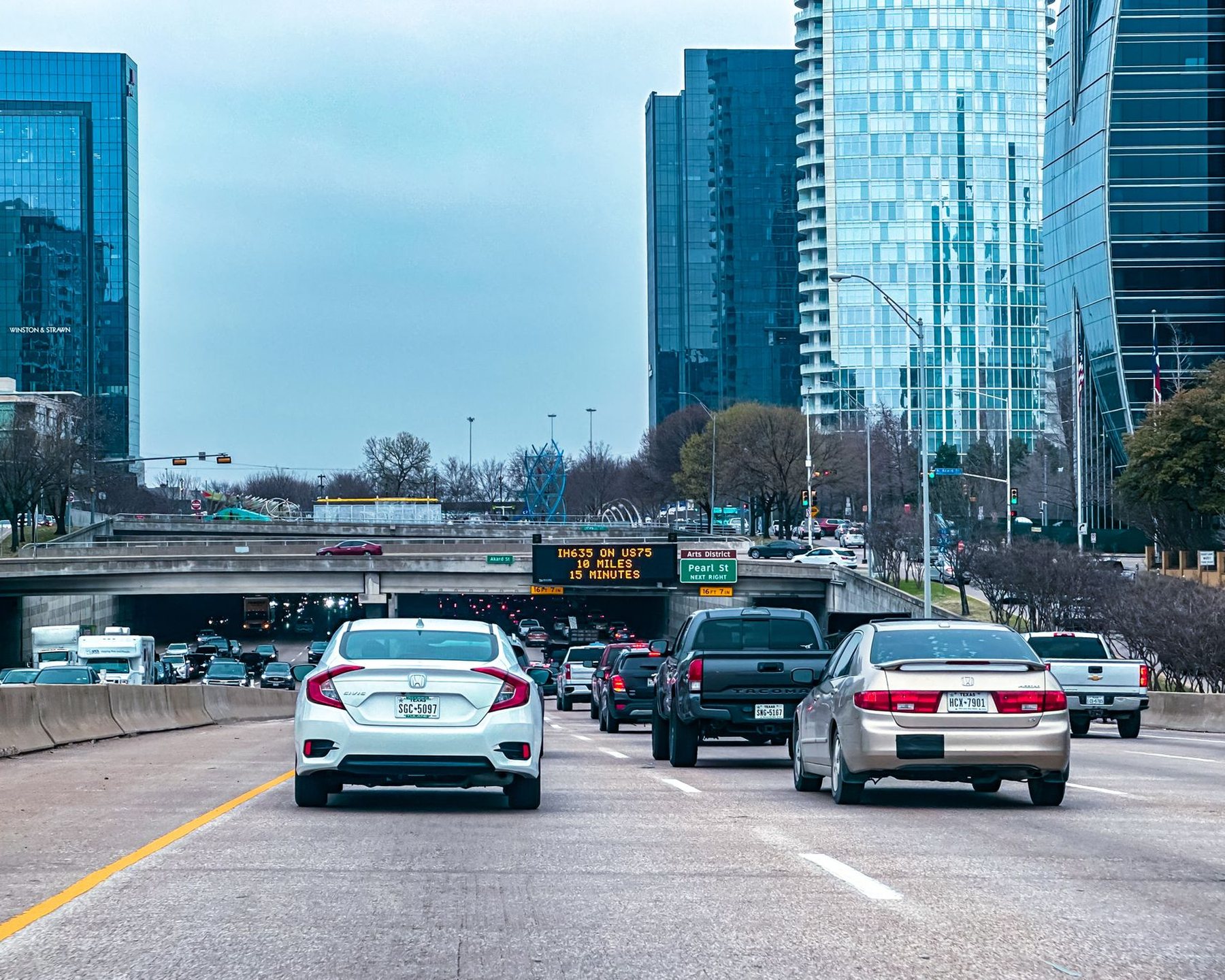 Traffic on a highway with a city skyline behind it